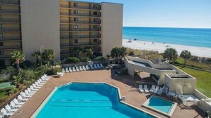 A hotel with a rooftop pool, lounge chairs, and a view of the beach. - Chill Beach front complex Two Queens at Top of the Gulf (Panama City Beach)