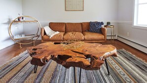 A living room with a leather sofa, a wooden coffee table, and a patterned rug. - Private Retreat w/Pool, Hot Tub & Fire Pit, Perfect for Groups! (Warwick)