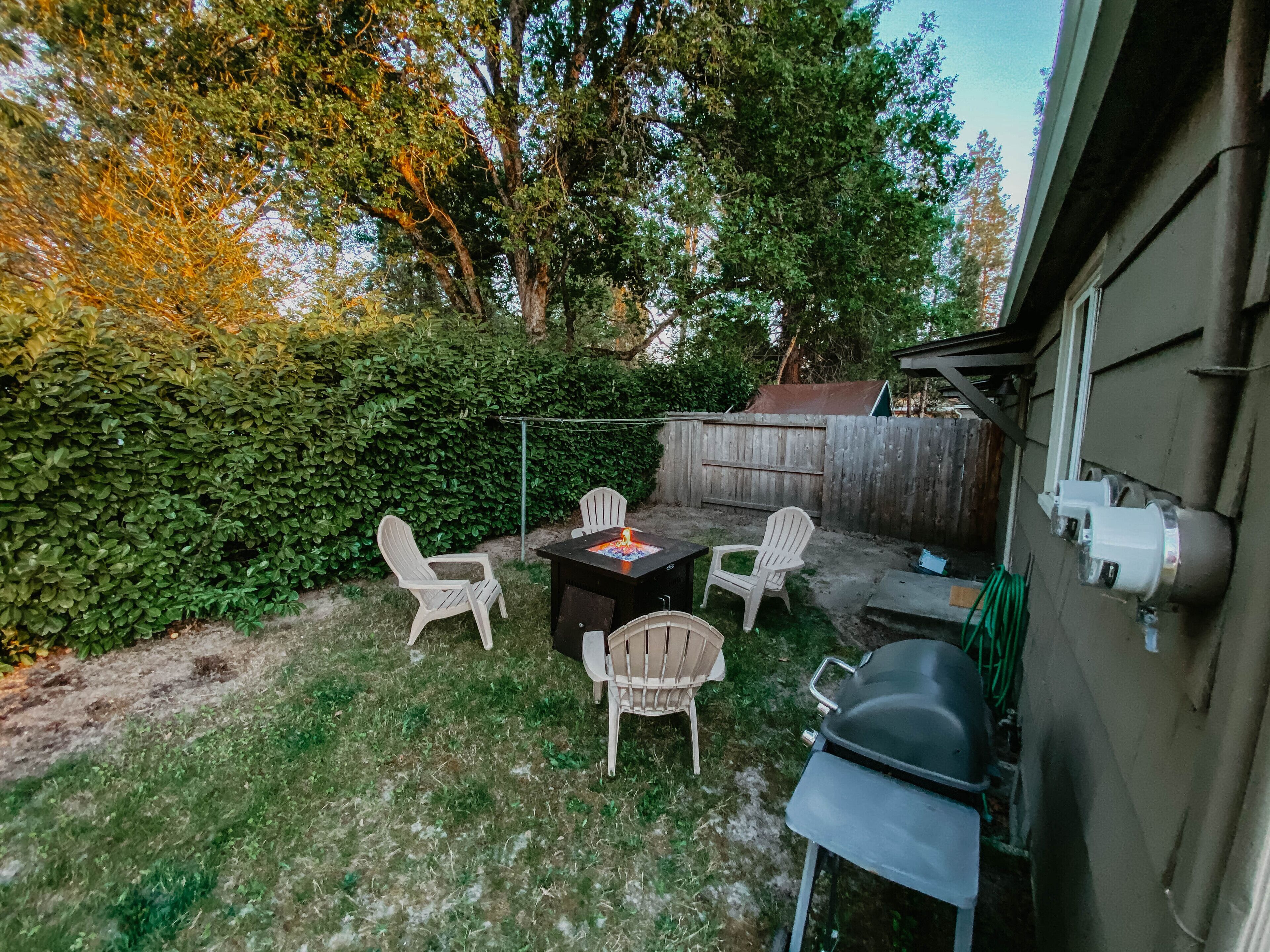 Un pati amb terrassa de fusta, una barbacoa i mobiliari d'exterior.