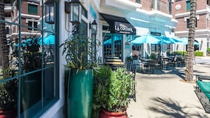 A restaurant with outdoor seating, a large planter, and a sign reading "LA COCINA Mexican Grill & Bar". - Village Of South Walton #263A | Luxe Condo in the Village! (Seacrest Beach)