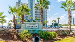 A sign for the Tidewater Condominium with a clear view of the building in the background. - Tidewater #1003 | Gulf Front Orange Beach Condo! (Orange Beach)