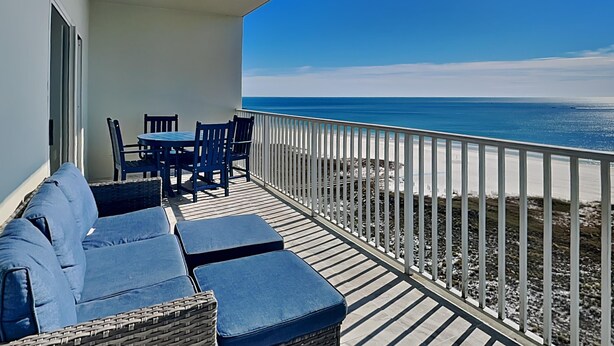 A balcony with a view of the ocean, a table with chairs, and a sofa. - Tidewater #1003 | Gulf Front Orange Beach Condo! (Orange Beach)