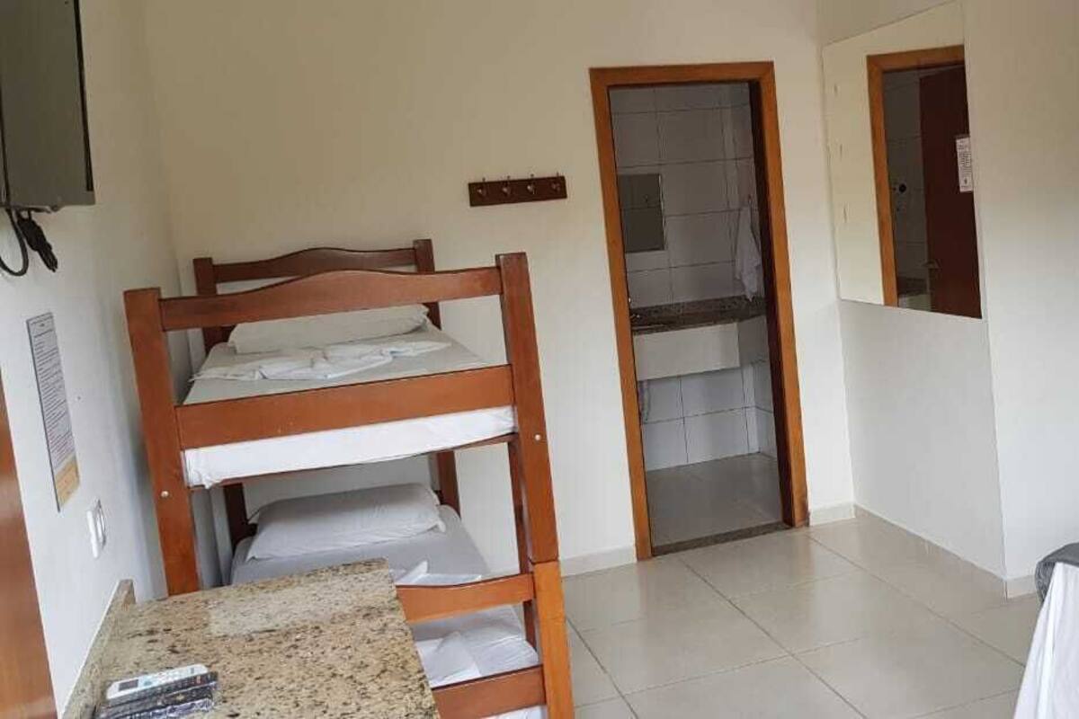 Una habitación con literas, un pequeño kitchenette y un refrigerador.