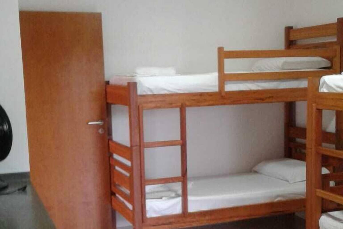 Habitación con literas, escritorio y silla.