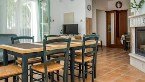 A dining area with a wooden table and chairs, a television, and a fireplace. - Wonderful private villa for 12 guests with private pool, A/C, WIFI, TV and terrace (Keszthely)