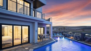Un hotel moderno con piscina, mobiliario exterior y vistas del paisaje.