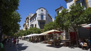 A street with outdoor seating, trees, and buildings.