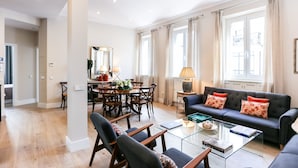 A spacious living room with a sofa, coffee table, and dining area.