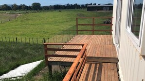 A wooden deck with a metal railing, overlooking a grassy field. - Studio unit self contained, peaceful setting, awesome views  (Tokoroa)