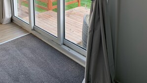 A room with large sliding glass doors leading to a wooden deck. - Studio unit self contained, peaceful setting, awesome views  (Tokoroa)