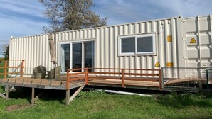A modular container home with a deck, a sliding door, and a fenced area. - Studio unit self contained, peaceful setting, awesome views  (Tokoroa)