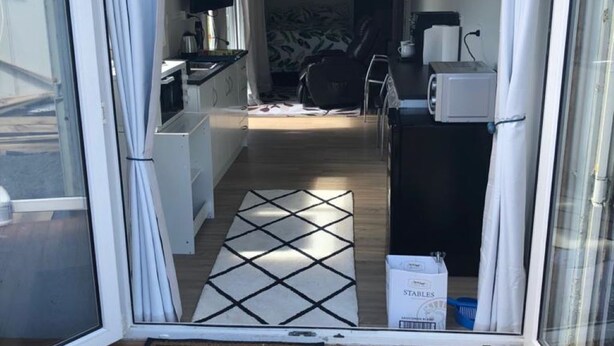 A view of a living area with a kitchen, a dining table, and a sofa. - Studio unit self contained, peaceful setting, awesome views  (Tokoroa)