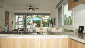 Una cocina moderna con armarios de madera, encimera de granito y un amplio ventanal con vistas al exterior.