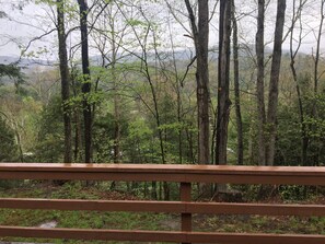 A forested area with a wooden railing in the foreground. - Paradise Ridge with beautiful Pine Creek view!!! (Gaines)