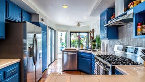 Una cocina moderna con armarios azules, electrodomésticos de acero inoxidable y una isla central.