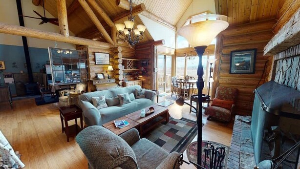 Un intérieur chaleureux de chalet en bois, comprenant un salon, un coin repas et une cuisine.