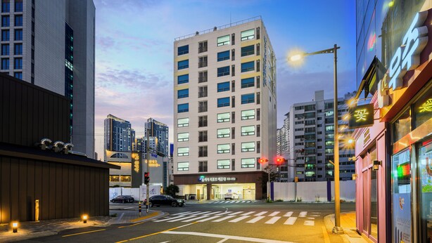 A modern hotel with a prominent entrance, large windows, and a clear view of the street. - Pol-A Resort Haeundae (Busan)