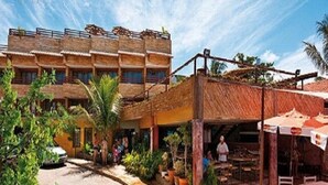 A multi-story building with a traditional architectural style, featuring balconies and a covered outdoor seating area.