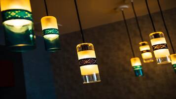 Una serie di lampade pendenti con luce calda, sospese al soffitto.