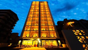 Un grand hôtel à plusieurs étages, doté de balcons et d’une entrée bien éclairée.