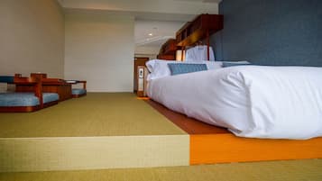 A hotel room with a bed, a seating area with a bench and a small table, and a wooden structure above the bed.