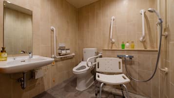 A bathroom with a sink, toilet, and wheelchair-accessible shower.