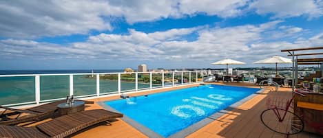 Seasonal outdoor pool, open 10:00 AM to 6:00 PM, pool umbrellas