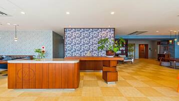 A reception area with a wooden reception desk, a patterned wall, and a checkered floor.