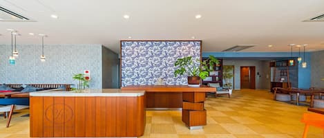 A reception area with a wooden reception desk, a patterned wall, and a checkered floor.