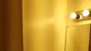 Un baño con lavamanos, espejo y retrete.