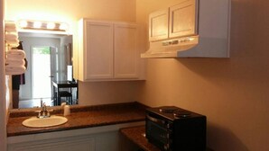 A bathroom with a sink, mirror, and white cabinets. - Unity Lodge Suite 2 (Golconda)