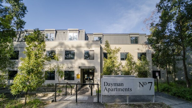 Un moderno edificio de apartamentos con un cartel que indica 'Dayman Apartments No 7'.