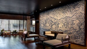 Una habitación tradicional con muebles de madera y un papel tapiz estampado.