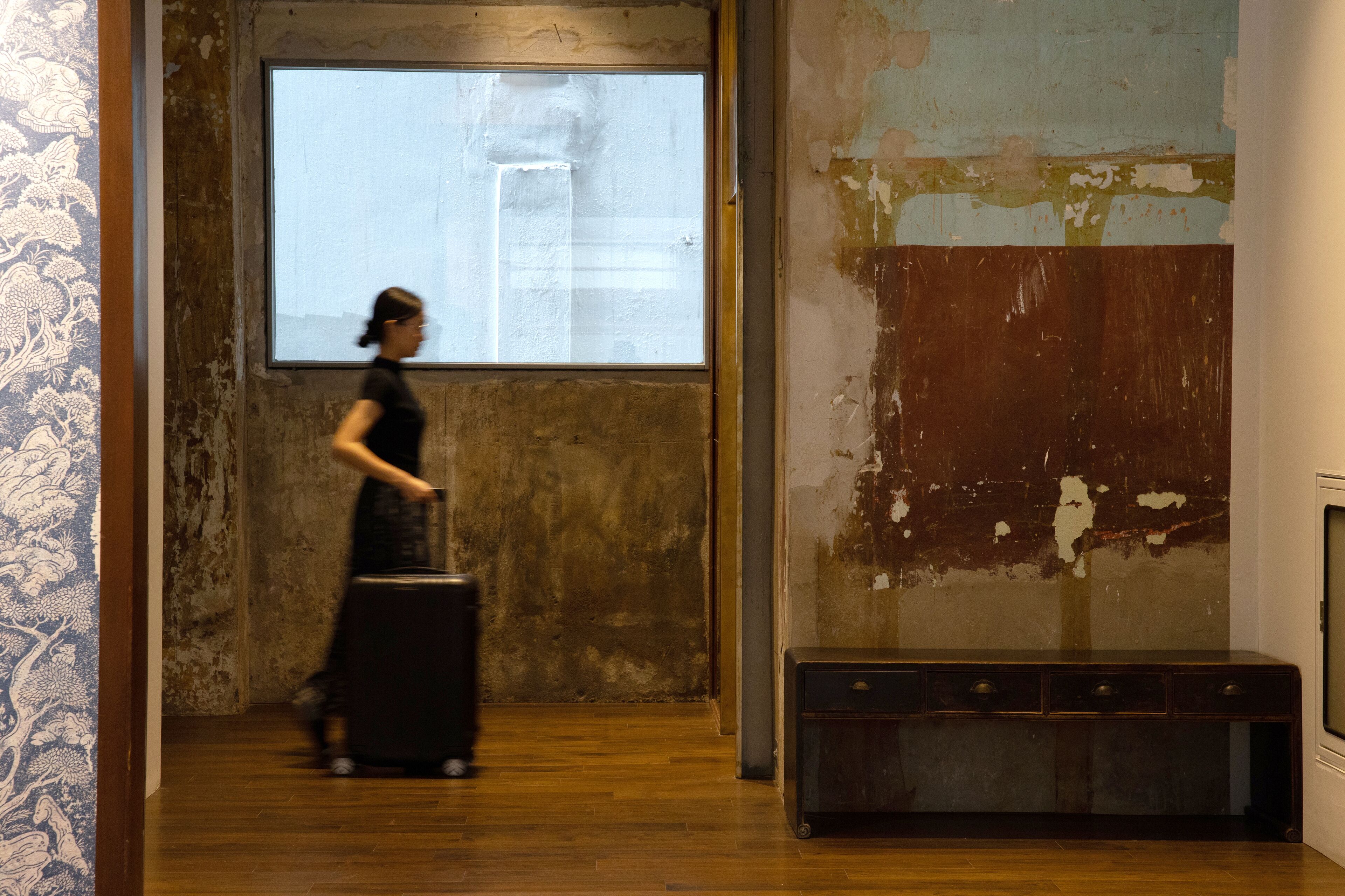 A room with a wooden floor, a large window, and a projector screen.
