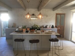 A kitchen with a large island, pendant lights, and bar stools. - Maison Avec Piscine. Ideal Pour LE Festival D'avignon ET D'orange (Villeneuve-lès-Avignon)