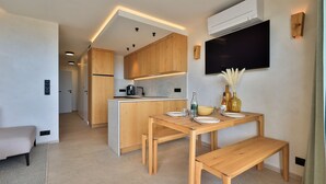 Een moderne keuken met houten kastjes, een centraal eiland en een eethoek met een bank.