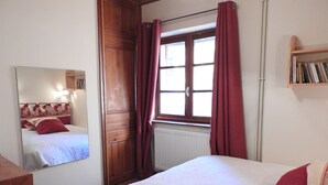A bedroom with a wooden wardrobe, a window with curtains, a bedside table, and a bookshelf. - 200 m FROM SKI SLOPES- HOUSE  FOR 12 PERSONS (Chantemerle)