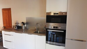 A modern kitchen with white cabinets, a stainless steel sink, and a built-in oven. - 200 m FROM SKI SLOPES- HOUSE  FOR 12 PERSONS (Chantemerle)