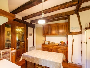 Una cocina con armarios de madera, un refrigerador blanco y una mesa con mantel.