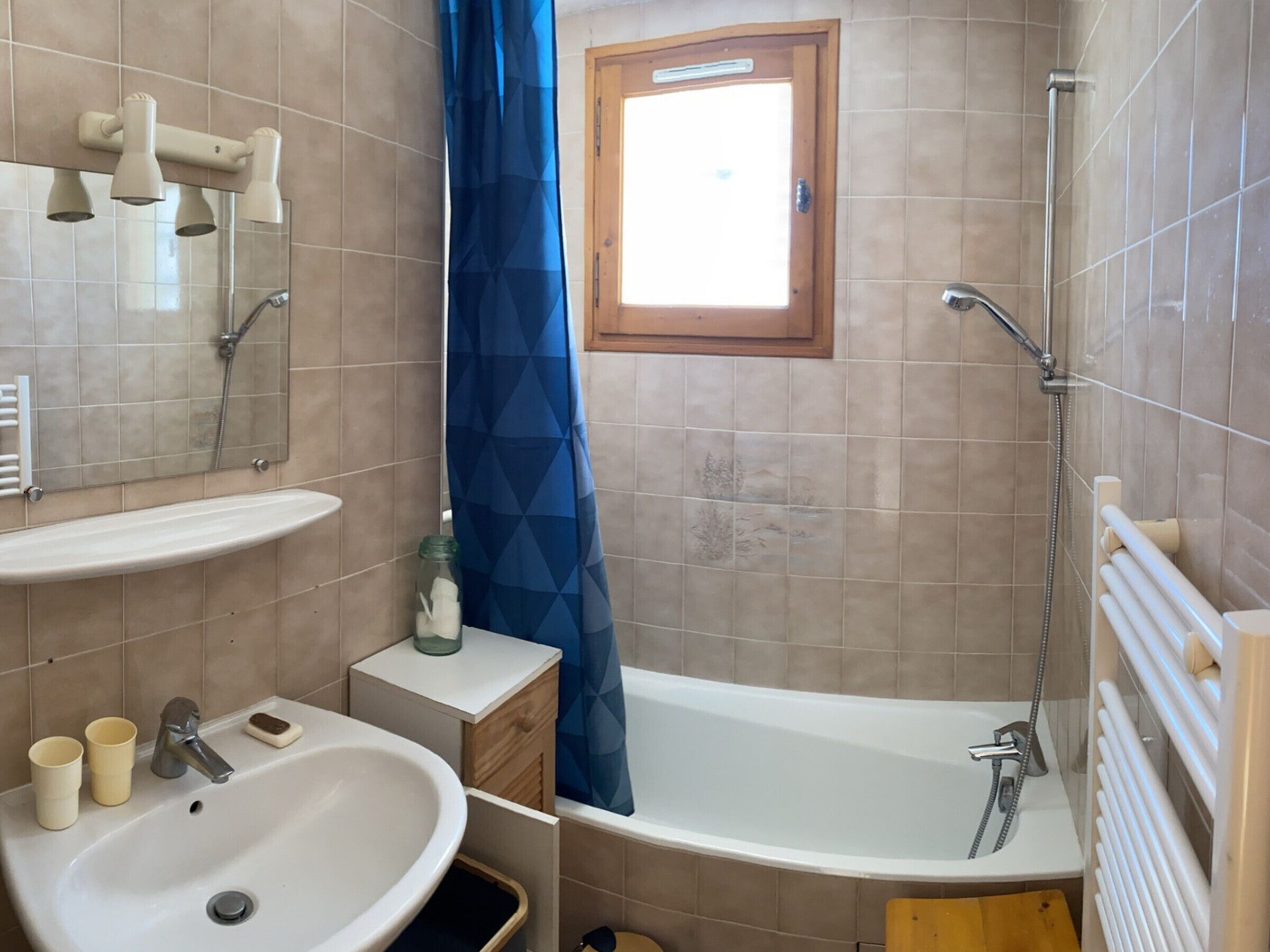 A bathroom with a sink, mirror, shower, and bathtub.