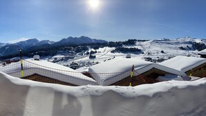 A snow-covered mountain landscape with buildings and ski slopes.