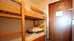 Habitación con literas, una puerta de madera y un pequeño letrero en ella.