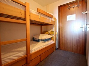 A bunk bed room with a wooden door and a small sign on it.
