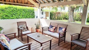 An outdoor patio with wooden furniture, including chairs and a table, under a wooden pergola. - Charming Cottage near Loire River with Garden, Covered Terrace & Easy Access to Saumur Attractions (Brain-sur-Allonnes)
