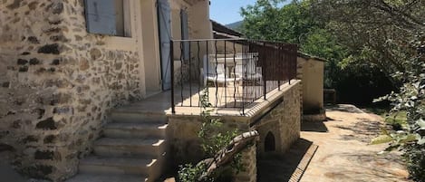 Un escalier en pierre menant à un balcon doté d’une rambarde en métal.