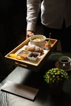 A tray with food items including a bowl of soup, pastries, and a cup of coffee.