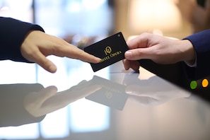A person holding a black card with "HOTEL OPERA" written on it.