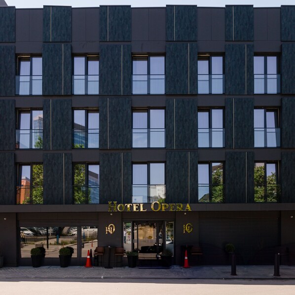 A modern hotel facade with a prominent "HOTEL OPERA" sign, large windows, and a clean entrance. - Hotel Opera (Pristina)