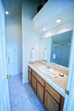 A bathroom with a sink, mirror, and cabinets.