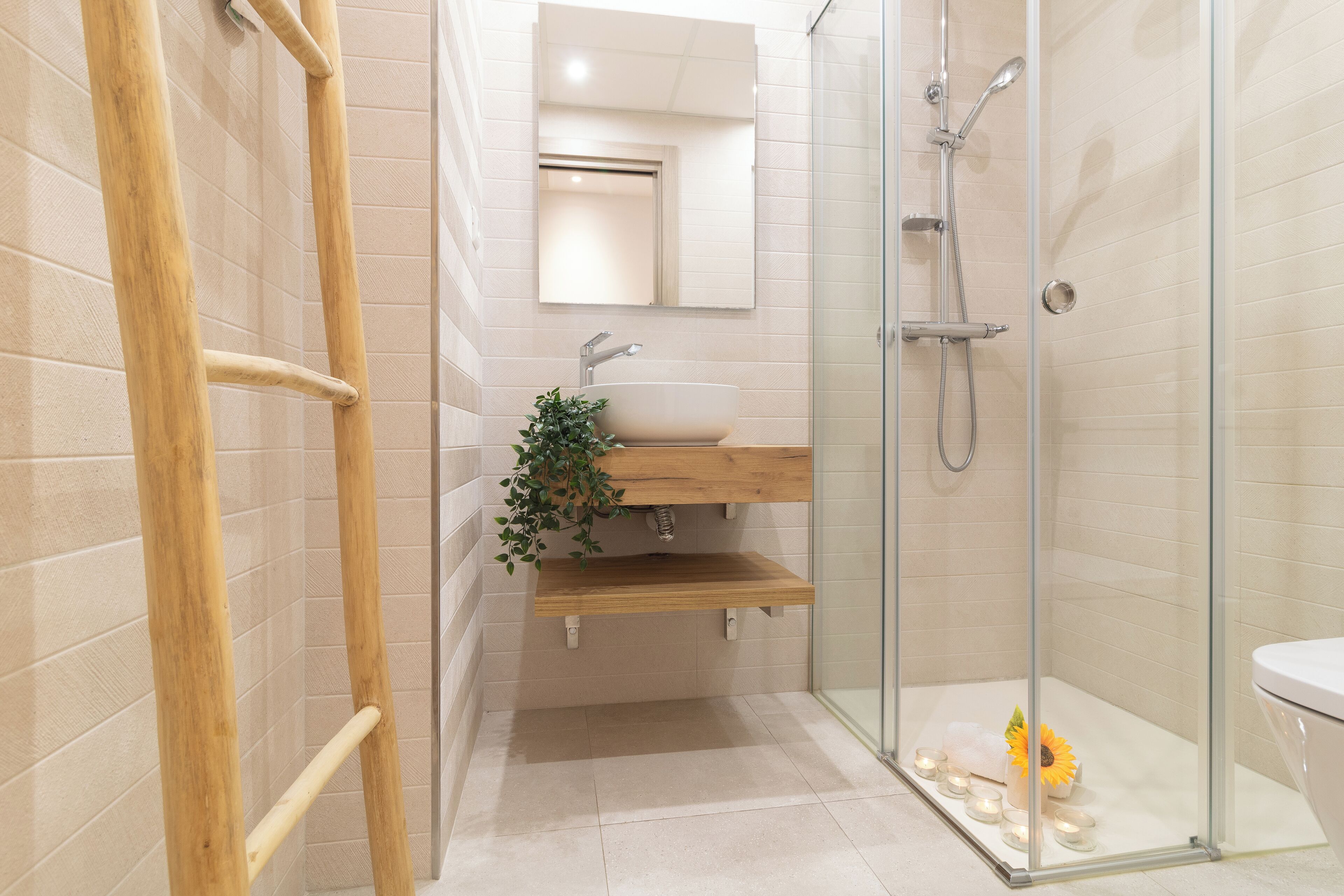 A modern bathroom with a glass shower enclosure, a wooden vanity, and a white sink.